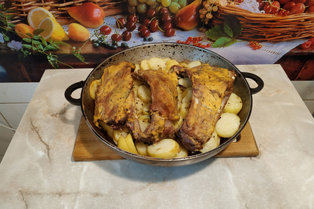 Фото к рецепту: Бараньи ребрышки запеченные с картофелем