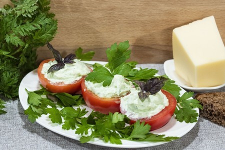 Фото к рецепту: Закуска из фаршированных творогом и сыром помидоров