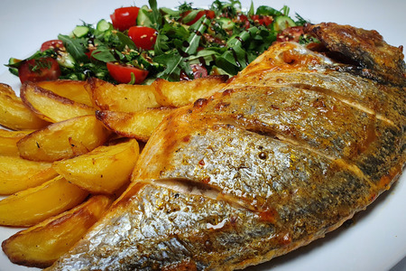 Фото к рецепту: Запечённый картофель с рыбой в духовке