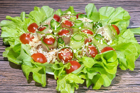 Фото к рецепту: Салат с тунцом и свежими овощами в листьях салата