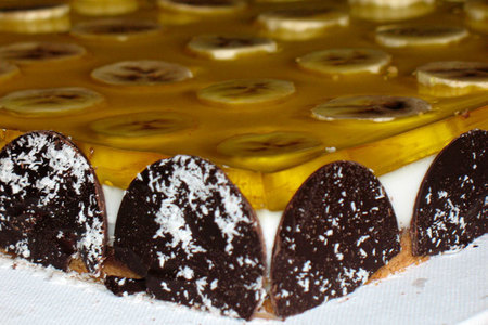 Фото к рецепту: Шоколадный (печёный) чизкейк с кокосовым покрытием и бананами под шафрановым желе